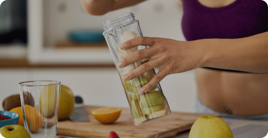 A woman fills a jar with zucchini for canning